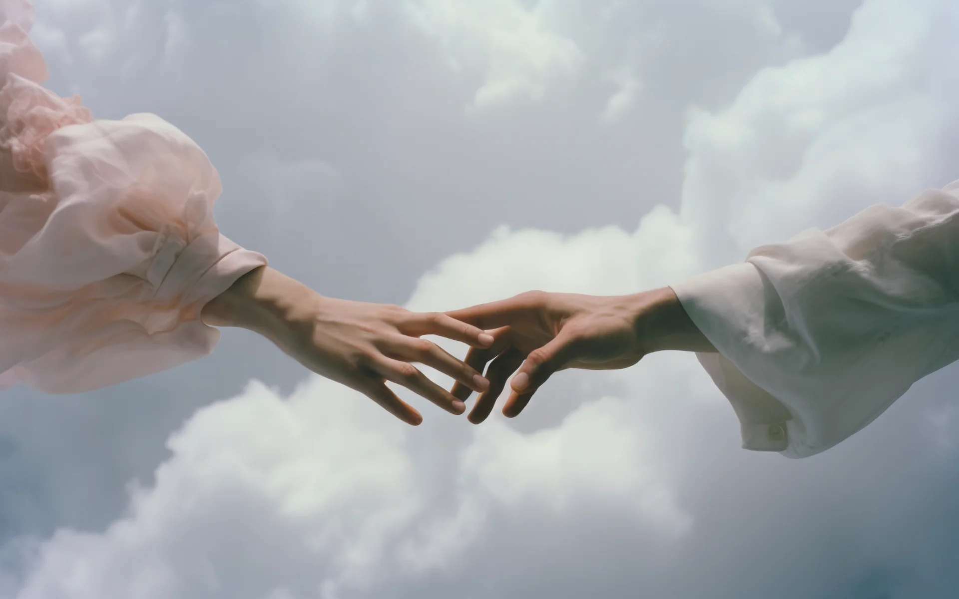Two hands reaching toward each other against a cloudy sky